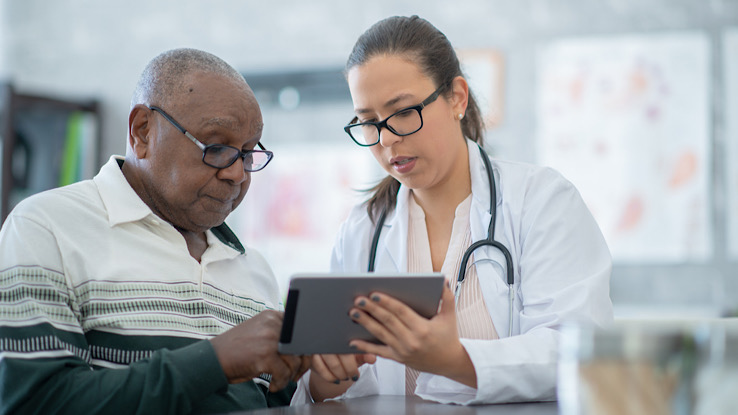 Female doctor speaking to male patient about colon cancer screening options